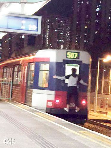 香港：小伙跳上轻轨贴车尾 呈现大字形如蜘蛛