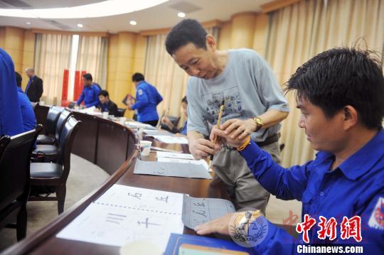 老挝青年在中国老师的指导下学习书法。 蒋雪林 摄